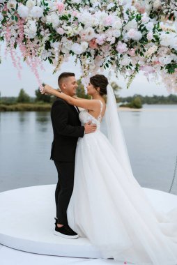 wedding ceremony of the newlyweds on the pier near the restaurant