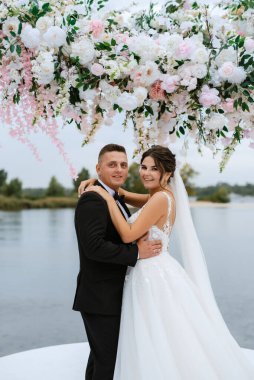 wedding ceremony of the newlyweds on the pier near the restaurant