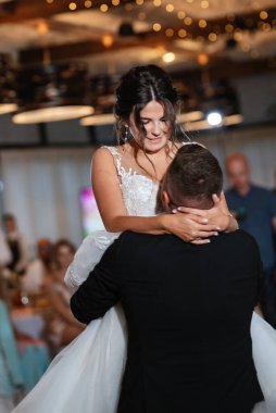 the first dance of the bride and groom inside a restaurant with heavy smoke