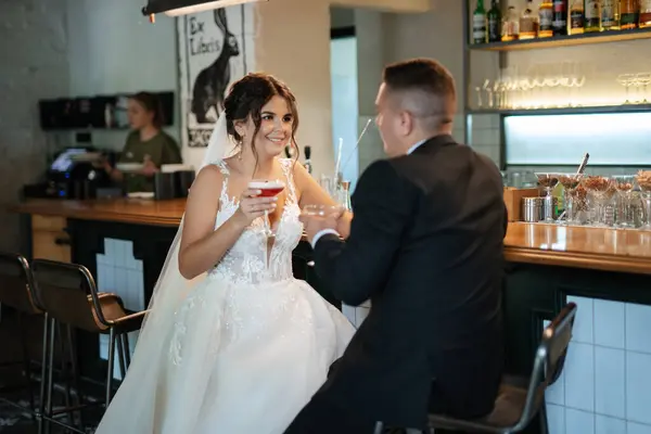Gelin ve damat, canlı bir atmosferde bir kokteyl barında.