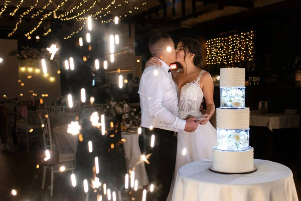 newlyweds happily cut, laugh and taste the wedding cake