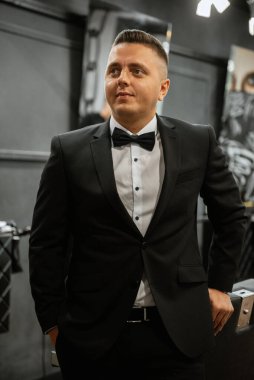 Beyefendinin berber dükkanında sakalını kesen sakallı adam.