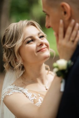 the groom and the bride are walking in the forest on a bright day