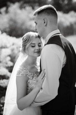the groom and the bride are walking in the forest on a bright day
