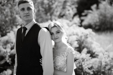 the groom and the bride are walking in the forest on a bright day