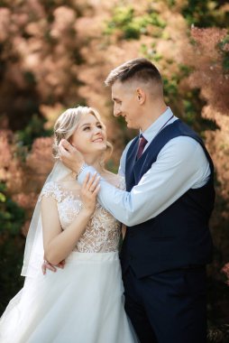 the groom and the bride are walking in the forest on a bright day