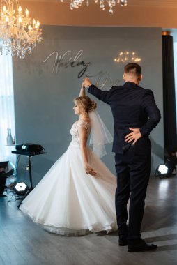 Gelin ve damadın ilk düğün dansı gün batımında restoranın içinde.