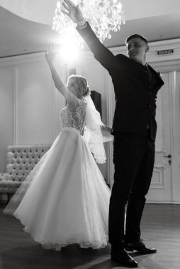 Gelin ve damadın ilk düğün dansı gün batımında restoranın içinde.