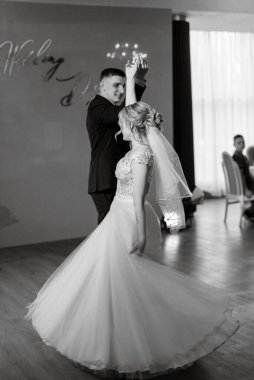 Gelin ve damadın ilk düğün dansı gün batımında restoranın içinde.