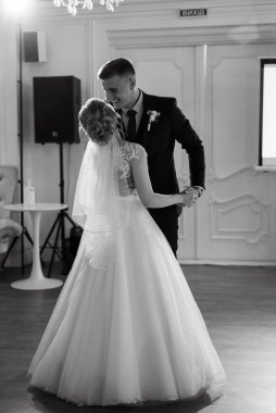 Gelin ve damadın ilk düğün dansı gün batımında restoranın içinde.