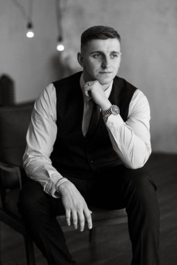 Stüdyoda mavi takım elbiseli neşeli bir damadın portresi.