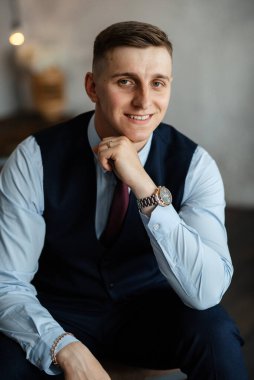 Stüdyoda mavi takım elbiseli neşeli bir damadın portresi.