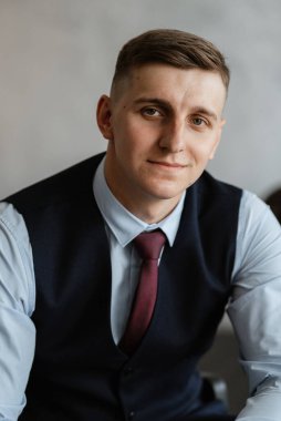 Stüdyoda mavi takım elbiseli neşeli bir damadın portresi.