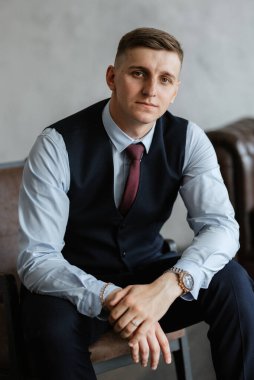 Stüdyoda mavi takım elbiseli neşeli bir damadın portresi.