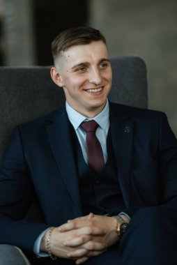 Stüdyoda mavi takım elbiseli neşeli bir damadın portresi.