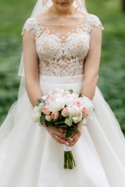 Bahar ormanında, düğün gününde beyaz elbiseli genç bir kız.