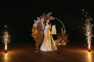 newlyweds happily cut, laugh and taste the wedding cake