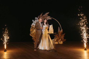 newlyweds happily cut, laugh and taste the wedding cake