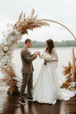 wedding ceremony of the newlyweds on the pier near the restaurant