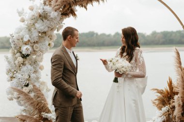 wedding ceremony of the newlyweds on the pier near the restaurant
