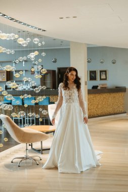 Gelinlik giymiş genç bir kız damatla otel lobisinde buluşmaya gider.