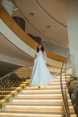 Gelinlik giymiş genç bir kız damatla otel lobisinde buluşmaya gider.