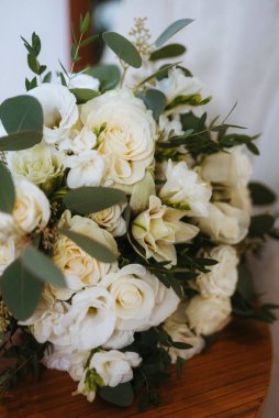 Taze doğal çiçekler ve yeşillik dolu zarif bir düğün buketi.