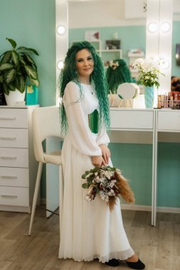 Sabah güzellik salonunda yeşil kıvırcık saçlı bir gelinin portresi.