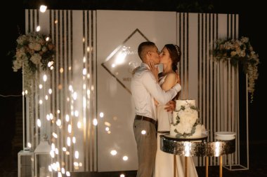 newlyweds happily cut, laugh and taste the wedding cake