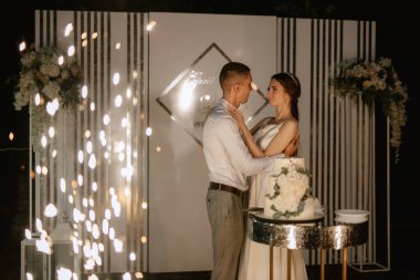 newlyweds happily cut, laugh and taste the wedding cake