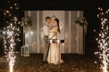 newlyweds happily cut, laugh and taste the wedding cake