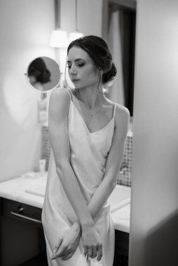 bride in a veil with makeup paints her lips in the bathroom