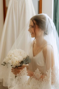 preparations for the bride with the dressing of the wedding dress in the studio