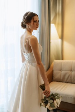 preparations for the bride with the dressing of the wedding dress in the studio