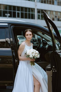 Gelin cam bir gökdelenin yanında siyah bir araba ile