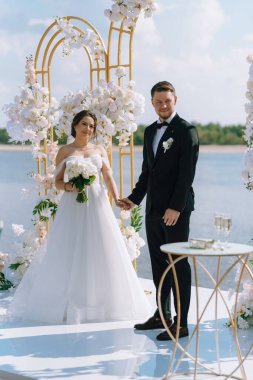 wedding ceremony of the newlyweds on the pier near the restaurant