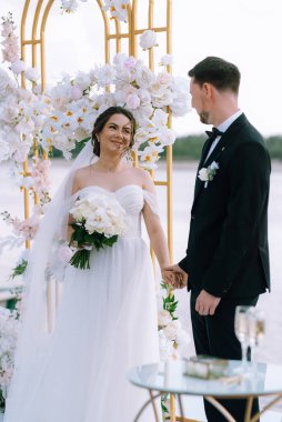 wedding ceremony of the newlyweds on the pier near the restaurant