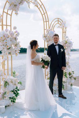 wedding ceremony of the newlyweds on the pier near the restaurant