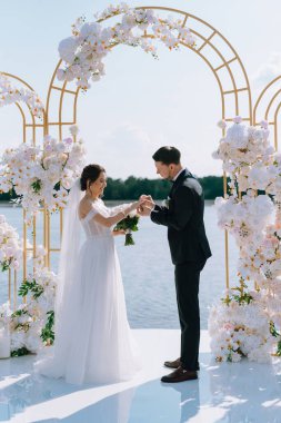 wedding ceremony of the newlyweds on the pier near the restaurant
