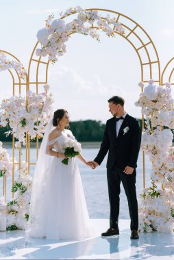 wedding ceremony of the newlyweds on the pier near the restaurant