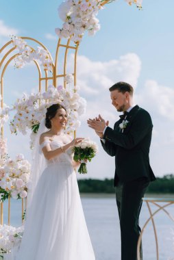 wedding ceremony of the newlyweds on the pier near the restaurant