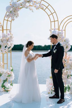 wedding ceremony of the newlyweds on the pier near the restaurant