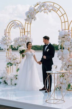 wedding ceremony of the newlyweds on the pier near the restaurant