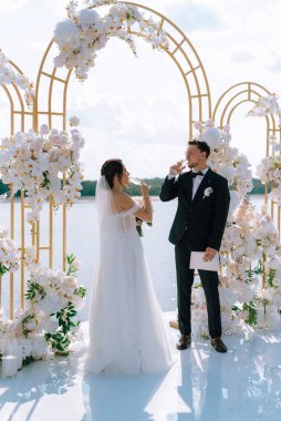 wedding ceremony of the newlyweds on the pier near the restaurant