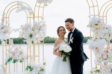wedding ceremony of the newlyweds on the pier near the restaurant
