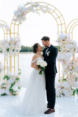 wedding ceremony of the newlyweds on the pier near the restaurant