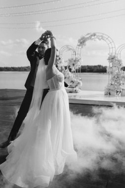 the first dance of the bride and groom inside a restaurant with heavy smoke