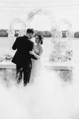the first dance of the bride and groom inside a restaurant with heavy smoke