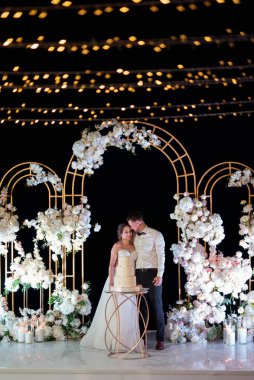 newlyweds happily cut, laugh and taste the wedding cake