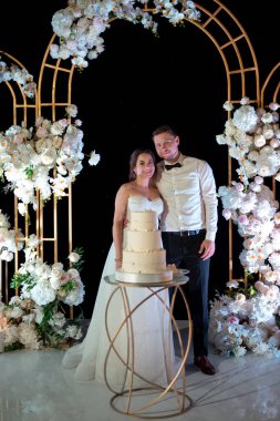 newlyweds happily cut, laugh and taste the wedding cake